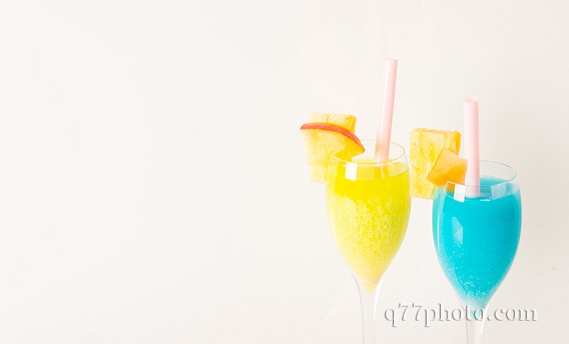yellow and blue drinks decorated with fruit, drink straw, apple 